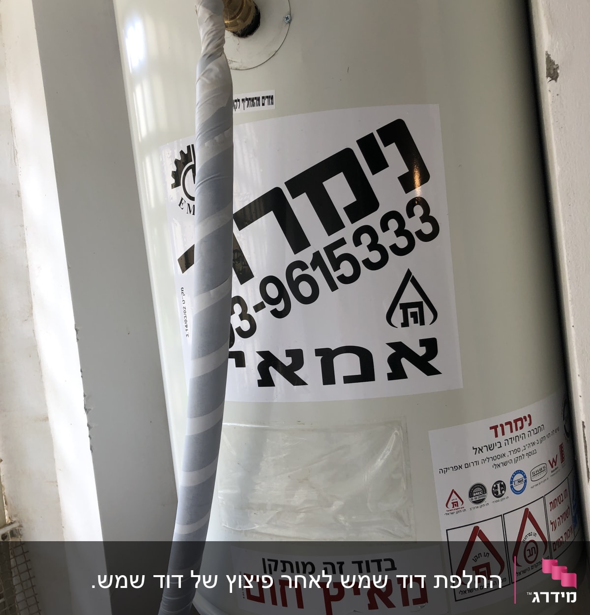דוד שמש עם מדבקות אזהרה וצינור עטוף